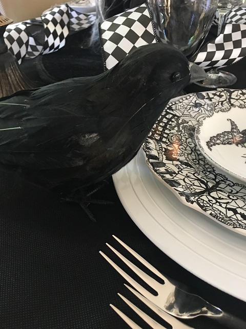 raven sitting beside place setting.