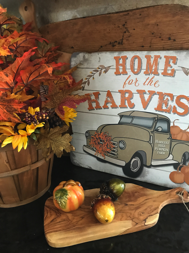 Autumn home for harvest vignette with farm truck full of pumpkins.