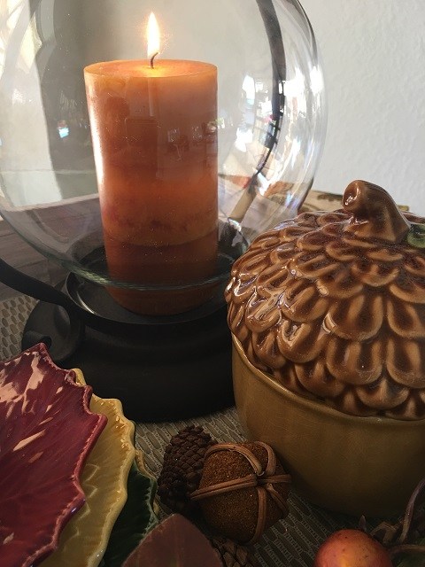 pumpkin colored candle in hurricane vase